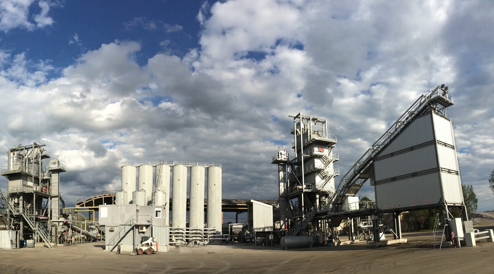 Asphalt production plant with silos, mixing tower, and material handling conveyors